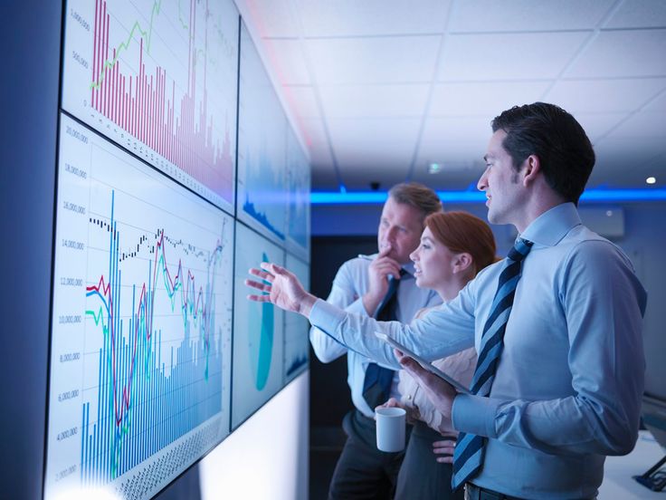 Business professionals analyzing data on large screens to develop an effective digital marketing strategy. Tips on online marketing strategies and digital marketing tips for success.‍